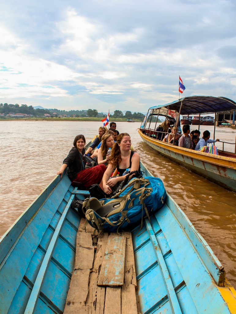 Backpackers får åka longtailbåt till Laos över floden från den Thailändska sidan.