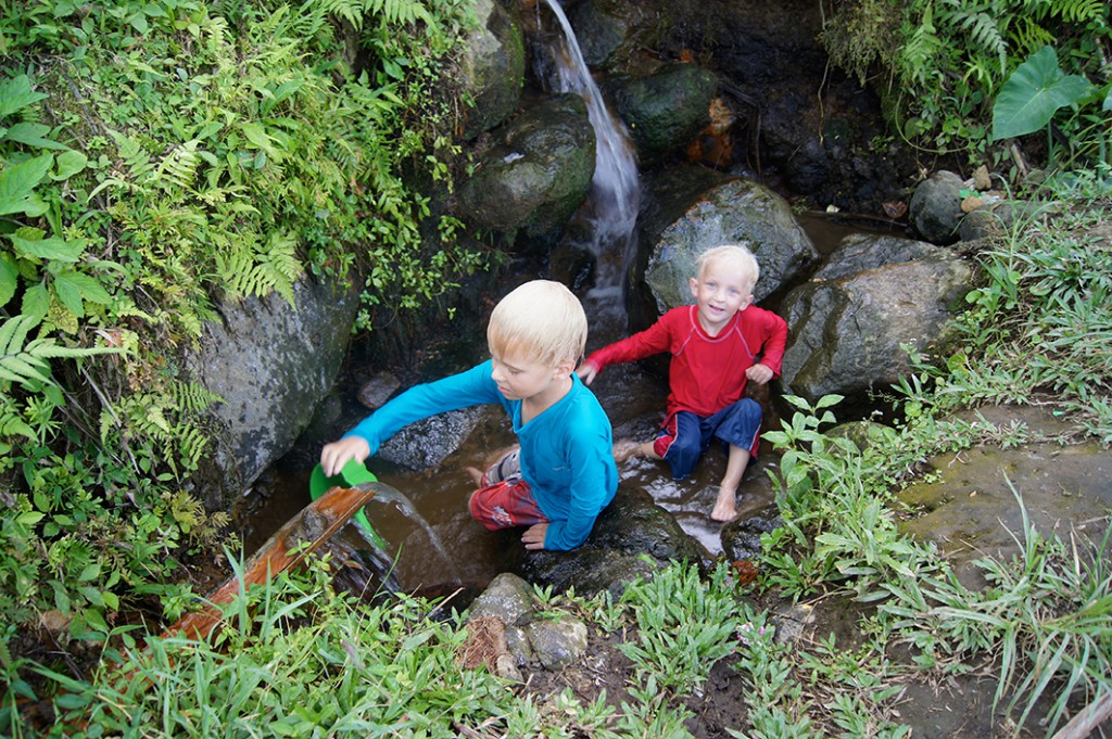 Milo och Jack badar i vattendrag bland risodlingarna på Balis landsbygd. Foto: Privat